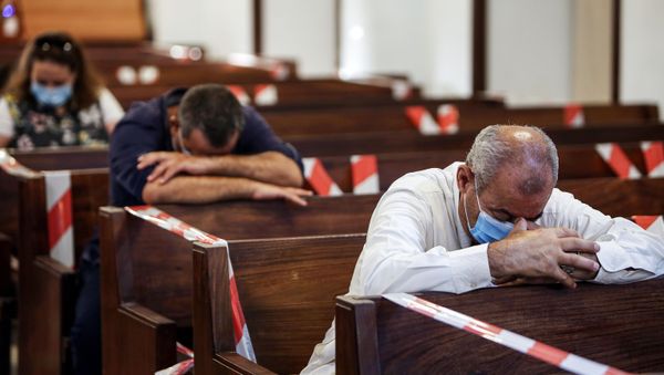 Mask-clad worshippers pray while seated in distanced pews during a service at the National Evangelical Church in Kuwait City on July 9, 2020 for the first time since the lifting of a lockdown due to the COVID-19 coronavirus pandemic. - Sputnik International