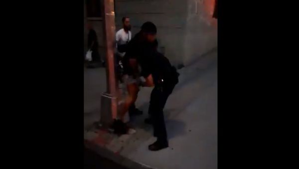 An unidentified protester gets NYPD police officer in a headlock - Sputnik International
