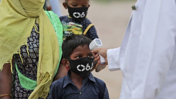 The child of a migrant worker gets his temperature checked before being allowed to board a train tomorrow with his family members for their hometown, in Jammu, India, Thursday, June 11, 2020. Two and a half months of nationwide lockdown kept numbers of infections relatively low in India. But with restrictions easing in recent weeks, cases have shot up with India's tally becoming the fifth highest in the world, raising questions about whether authorities have done enough to avert catastrophe. (AP Photo/Channi Anand) - Sputnik International