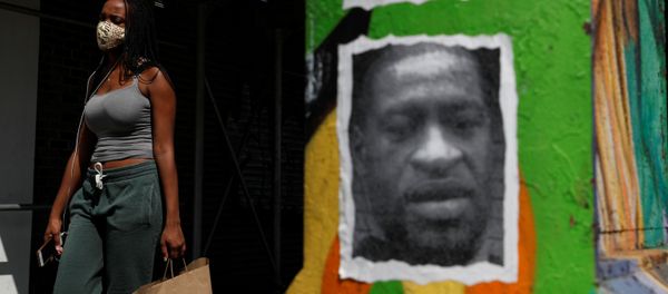 A woman walks with a protective face covering past a mural of George Floyd, in the aftermath of his death in Minneapolis police custody, along 125th street in the Harlem neighborhood of New York City, New York, U.S., July 9, 2020. A woman walks with a protective face covering past a mural of George Floyd, in the aftermath of his death in Minneapolis police custody, along 125th street in the Harlem neighborhood of New York City, New York, U.S., July 9, 2020. - Sputnik International