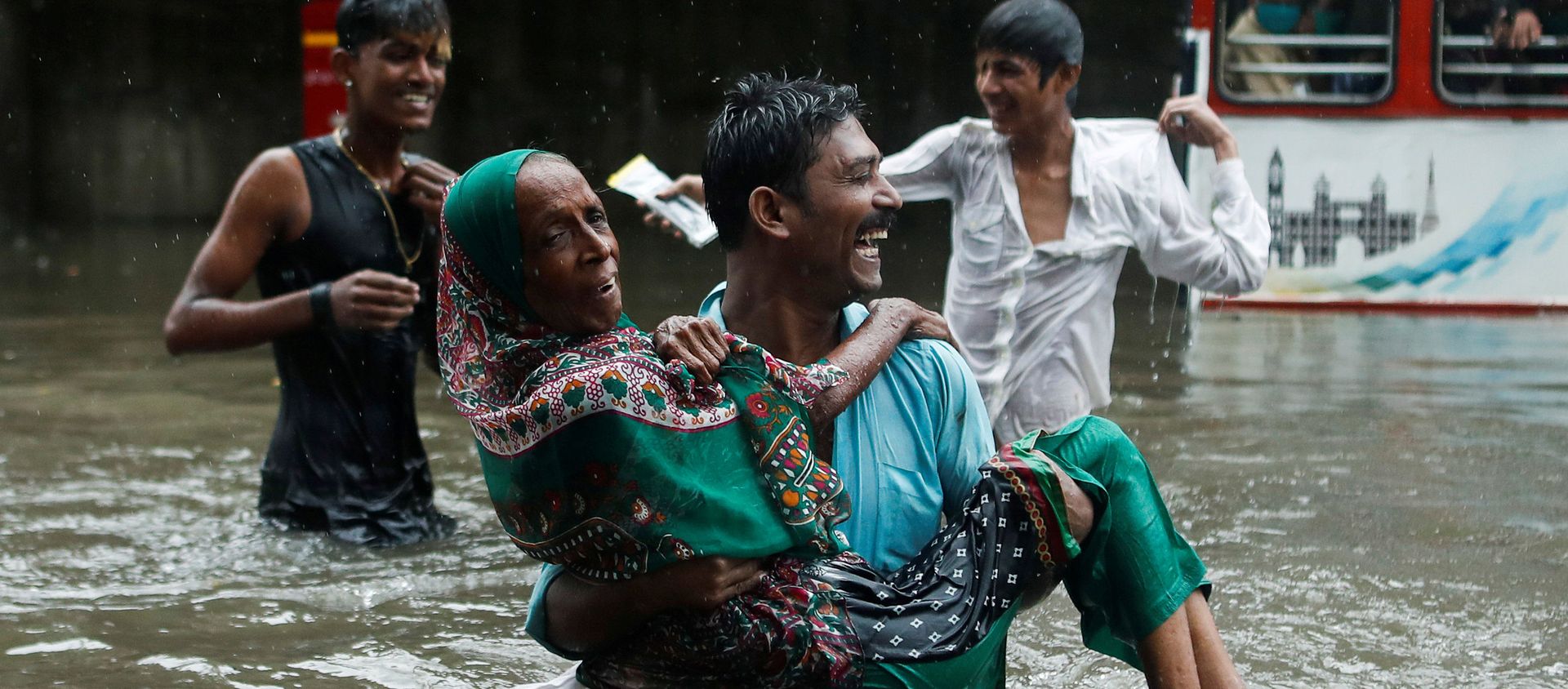 A man carries an elderly woman as they cross a waterlogged street during heavy rainfall in Mumbai, India, July 15, 2020 A man carries an elderly woman as they cross a waterlogged street during heavy rainfall in Mumbai, India, July 15, 2020 - Sputnik International, 1920, 16.07.2020