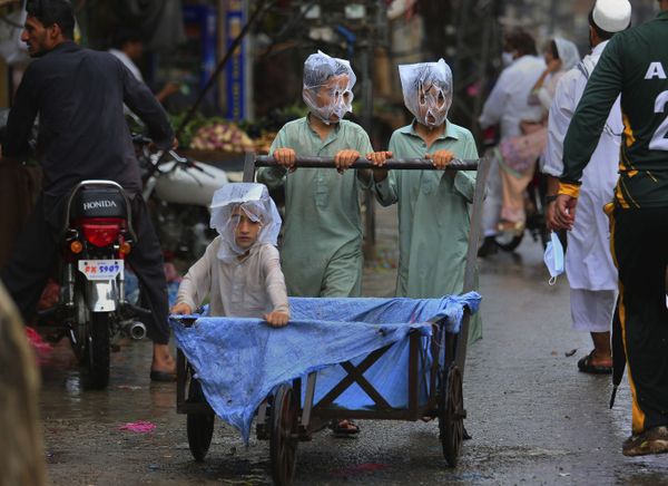 Youths cover their faces with plastic bags while pushing a handcart during rainfall in Peshawar, Pakistan, Sunday, July 12, 2020 - Sputnik International