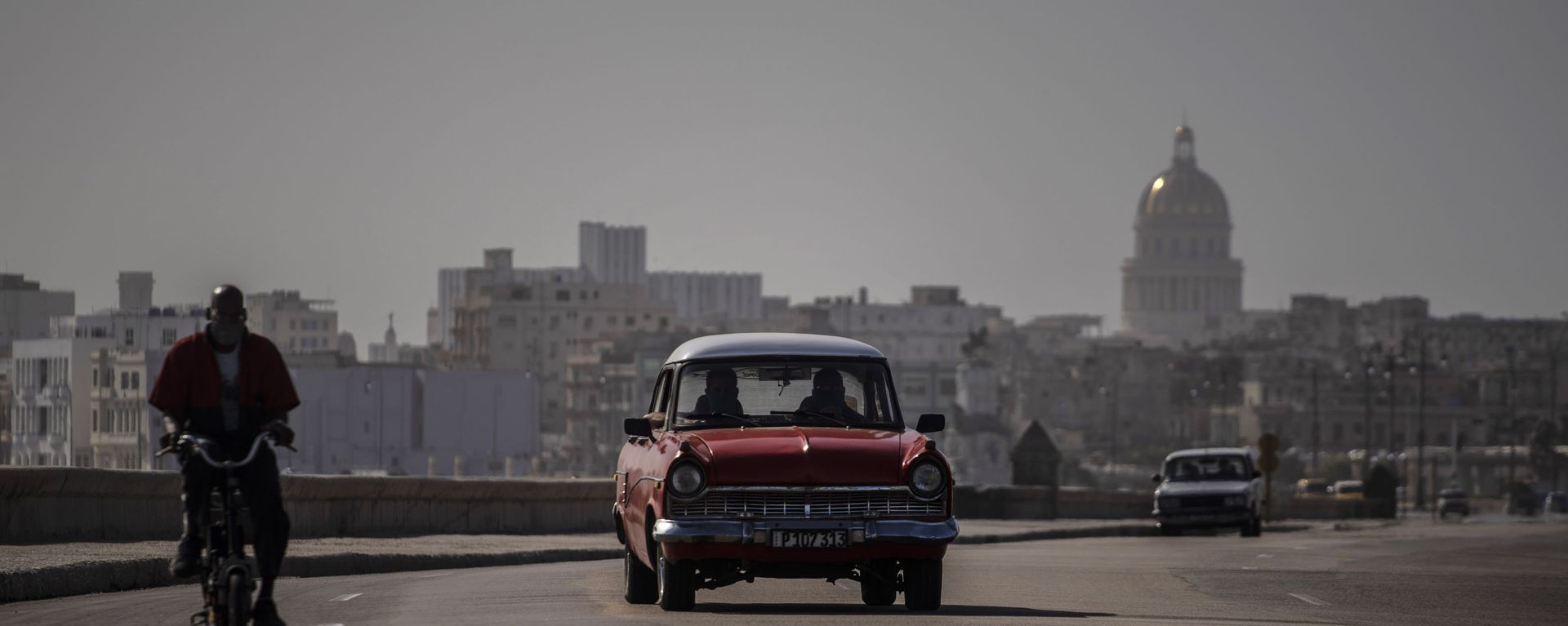 An American classic car and bicycle share the road on the Malecon amid a cloud of Sahara dust in Havana, Cuba, Thursday, June 25, 2020. An American classic car and bicycle share the road on the Malecon amid a cloud of Sahara dust in Havana, Cuba, Thursday, June 25, 2020. - Sputnik International, 1920, 20.10.2024