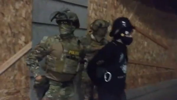 Two police officers of unknown affiliation arrest a protester in Portland, Oregon, on July 15, 2020 - Sputnik International