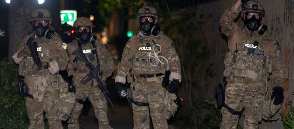 Federal law enforcement officers, deployed under the Trump administration's new executive order to protect federal monuments and buildings, face off with protesters against racial inequality in Portland, Oregon, U.S. July 17, 2020. Picture taken July 17, 2020. - Sputnik International