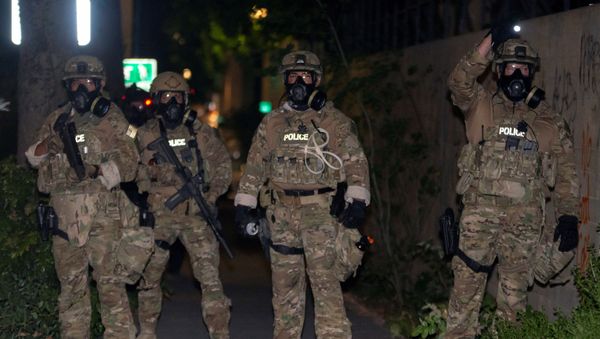 Federal law enforcement officers, deployed under the Trump administration's new executive order to protect federal monuments and buildings, face off with protesters against racial inequality in Portland, Oregon, U.S. July 17, 2020. Picture taken July 17, 2020. - Sputnik International