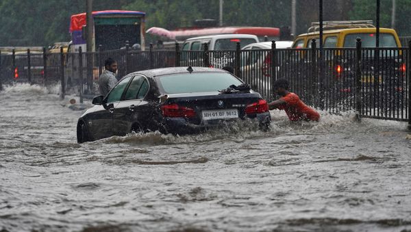 A man pushes a car, stuck in a flooded road, during heavy rains in Mumbai, India A man pushes a car, stuck in a flooded road, during heavy rains in Mumbai, India - Sputnik International