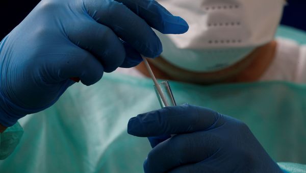 A French doctor, wearing a protective suit and a face mask, holds a test tube - Sputnik International