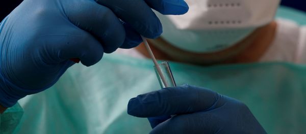 A French doctor, wearing a protective suit and a face mask, holds a test tube - Sputnik International