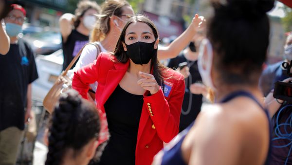 U.S. Rep. Alexandria Ocasio-Cortez (D-NY) speaks with local resident Upkar Chana and her daughter Aradhya Vaid while greeting voters during the Democratic congressional primary election in the Queens borough of New York City, New York, U.S., June 23, 2020.  - Sputnik International