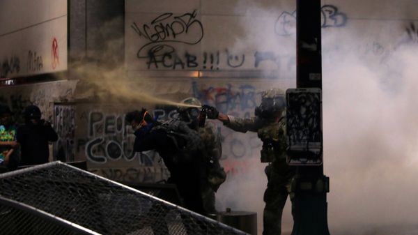 Federal law enforcement officers, deployed under the Trump administration's executive order to protect federal monuments and buildings, use pepper spray and tear gas on demonstrators during a protest against racial inequality in Portland, Oregon, U.S., July 19, 2020 - Sputnik International
