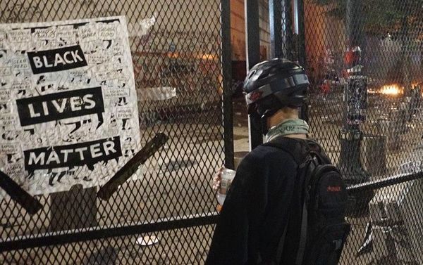 A protester stands near the federal courthouse in Portland on 23 July 2020 - Sputnik International