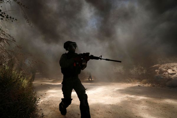 An Israeli border police member runs as smoke rises from burning tires during a Palestinian protest against Jewish settlements in the town of Beita in the Israeli-occupied West Bank July 18, 2020 An Israeli border police member runs as smoke rises from burning tires during a Palestinian protest against Jewish settlements in the town of Beita in the Israeli-occupied West Bank July 18, 2020 - Sputnik International