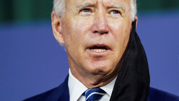 With a face mask hanging off his ear, Democratic U.S. presidential candidate and former Vice President Joe Biden speaks about the third part of his four-part economic recovery plan to revive the coronavirus-battered U.S. economy during a campaign event in New Castle, Delaware, U.S., July 21, 2020. - Sputnik International