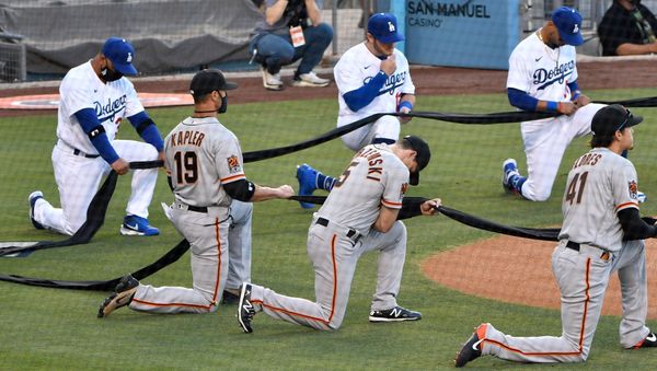 Los Angeles Dodgers manager Dave Roberts and first baseman Max Muncy and Mookie Betts along with San Francisco Giants manager Gabe Kapler and right fielder Mike Yastrzemski and second baseman Wilmer Flores take a knee during the national anthem before playing an opening day game at Dodger Stadium - Sputnik International