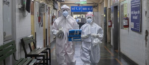 Medical workers wearing personal protective equipment (PPE) walk through a ward for patients suffering from the coronavirus disease  - Sputnik International