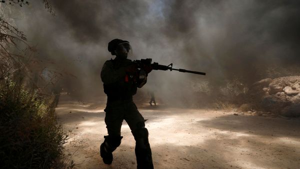 An Israeli border police member runs as smoke rises from burning tires during a Palestinian protest against Jewish settlements in the town of Beita in the Israeli-occupied West Bank July 18, 2020 An Israeli border police member runs as smoke rises from burning tires during a Palestinian protest against Jewish settlements in the town of Beita in the Israeli-occupied West Bank July 18, 2020 - Sputnik International