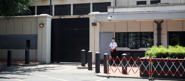 A member of security personnel stands guard in front of the former U.S. Consulate General with the signage and plaques covered with gray material in Chengdu, Sichuan province, China, July 27, 2020, after China ordered its closure in response to U.S. order for China to shut its consulate in Houston - Sputnik International