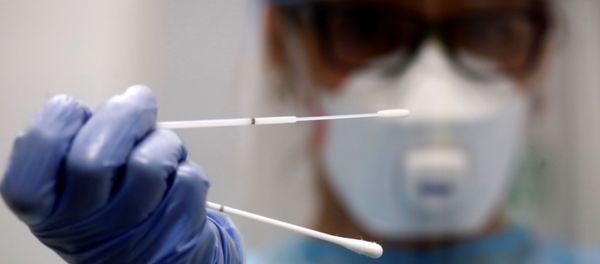 A retired doctor who volunteered to work at the new Duesseldorf Airport Corona Test Centre holds a test stick before a voluntary coronavirus disease A retired doctor who volunteered to work at the new Duesseldorf Airport Corona Test Centre holds a test stick before a voluntary coronavirus disease - Sputnik International