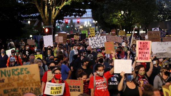 Demonstratrors hold placards as they march against racial inequality in downtown Portland, Oregon, U.S., July 25, 2020. - Sputnik International