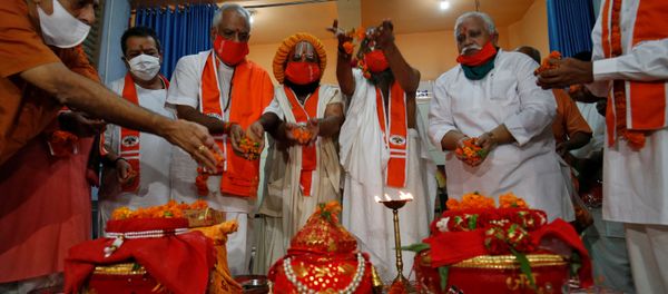 Hindu priests and supporters of the Vishva Hindu Parishad (VHP), a Hindu nationalist organisation, perform rituals next to pots filled with holy water and soil which they brought from various Hindu religious places, before taking the pots to the northern town of Ayodhya for a stone laying ceremony in the Ram Temple, in Ahmedabad, India July 27, 2020 - Sputnik International