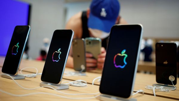 A man takes pictures of iPhones in the new Apple flagship store on its opening day following an outbreak of the coronavirus disease (COVID-19) in Sanlitun in Beijing, China, July 17, 2020 - Sputnik International