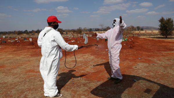 Funeral workers wearing personal protective equipment sanitise each other after a burial amid a nationwide coronavirus disease (COVID-19) lockdown, at the Olifantsvlei cemetery, south-west of Joburg, South Africa July 28, 2020. Funeral workers wearing personal protective equipment sanitise each other after a burial amid a nationwide coronavirus disease (COVID-19) lockdown, at the Olifantsvlei cemetery, south-west of Joburg, South Africa July 28, 2020. - Sputnik International