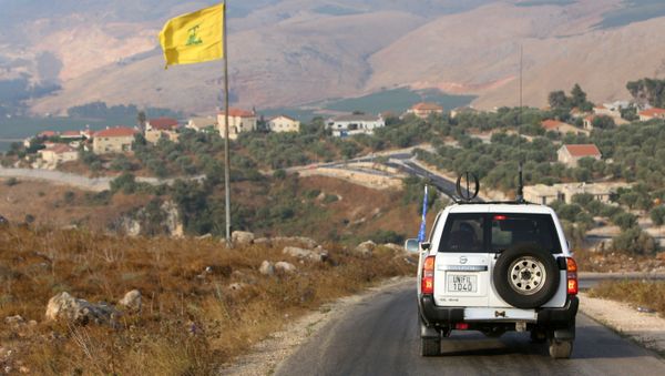 A UN peacekeepers (UNIFIL) vehicle drives past a Hezbollah flag in the southern Lebanese village of Khiam, near the border between Israel and Lebanon, 28 July 2020. - Sputnik International