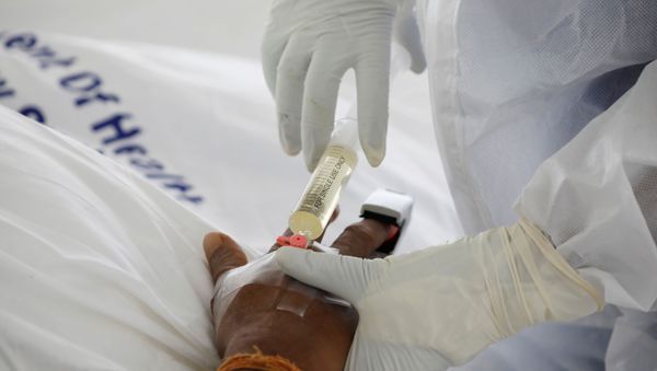 A nurse uses a syringe to give an injection to a COVID-19 patient inside a field hospital builtÊon a soccer stadium in Machakos, as the number of confirmed coronavirus disease (COVID-19) cases continues to rise in Kenya, July 23, 2020. Picture taken July 23, 2020.REUTERS/Baz Ratner - Sputnik International