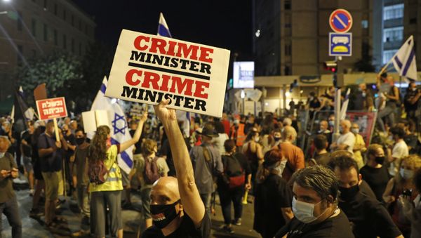 Israeli protesters hold placards as they take part in ongoing demonstrations against Prime Minister Benjamin Netanyahu in Jerusalem on July 30, 2020. - Sputnik International