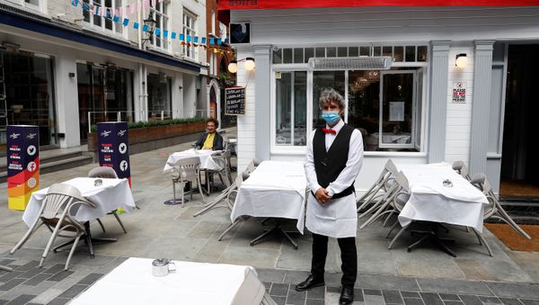 A waiter poses for photographs as he waits for customers outside a restaurant, after it reopened following the coronavirus disease (COVID-19) outbreak - Sputnik International