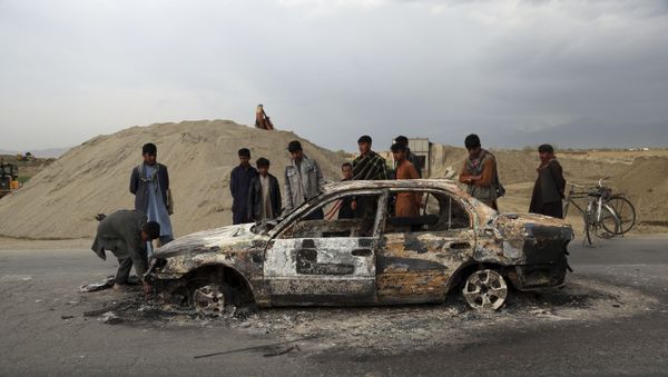 In this April 9, 2019, file photo, Afghans watch a civilian vehicle burnt after being shot by U.S. forces following an attack near the Bagram Air Base, north of Kabul, Afghanistan. Three American service members and a U.S. contractor were killed when their convoy hit a roadside bomb on Monday near the main U.S. base in Afghanistan, the U.S. forces said. The Taliban claimed responsibility for the attack. Intelligence alleging that Afghan militants might have accepted Russian bounties for killing American troops didn’t scuttle the U.S.-Taliban agreement or President Donald Trump’s plan to withdraw thousands more troops from the war - Sputnik International
