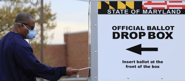 A resident drops off a mail-in ballot at the Edmondson Westside High School Polling site in Baltimore, Maryland, U.S., April 28, 2020 - Sputnik International