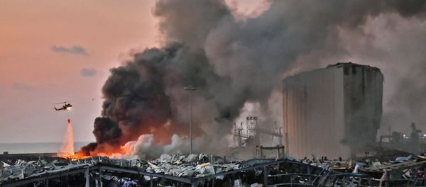 EDITORS NOTE: Graphic content / A helicopter puts out a fire at the scene of an explosion at the port of Lebanon's capital Beirut on August 4, 2020. (Photo by STR / AFP) - Sputnik International