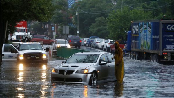 A man checks on a stranded vehicle during Tropical Storm Isaias, Tuesday, Aug. 4, 2020, in Philadelphia. The storm spawned tornadoes and dumped rain during an inland march up the U.S. East Coast after making landfall as a hurricane along the North Carolina coast. (AP Photo/Matt Slocum) - Sputnik International