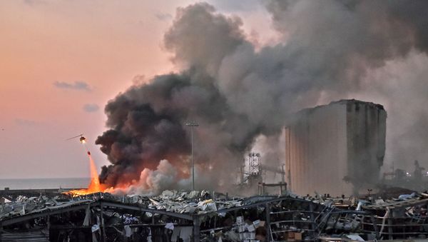 EDITORS NOTE: Graphic content / A helicopter puts out a fire at the scene of an explosion at the port of Lebanon's capital Beirut on August 4, 2020. (Photo by STR / AFP) - Sputnik International
