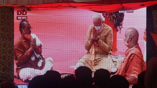 People watch a live telecast on a screen from Ayodhya of India's Prime Minister Narendra Modi taking part in a Hindu religious ritual during a groundbreaking ceremony of the Ram Temple, in New Delhi on August 5, 2020. People watch a live telecast on a screen from Ayodhya of India's Prime Minister Narendra Modi taking part in a Hindu religious ritual during a groundbreaking ceremony of the Ram Temple, in New Delhi on August 5, 2020. - Sputnik International