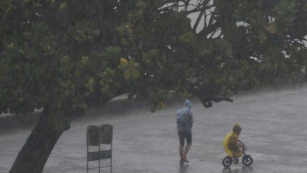 People walk under the rain along Marine Drive as rain falls in Mumbai on June 4, 2020, the day after cyclone Nisarga's landfall in India's western coast.  - Sputnik International