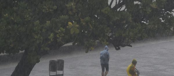 People walk under the rain along Marine Drive as rain falls in Mumbai on June 4, 2020, the day after cyclone Nisarga's landfall in India's western coast.  - Sputnik International