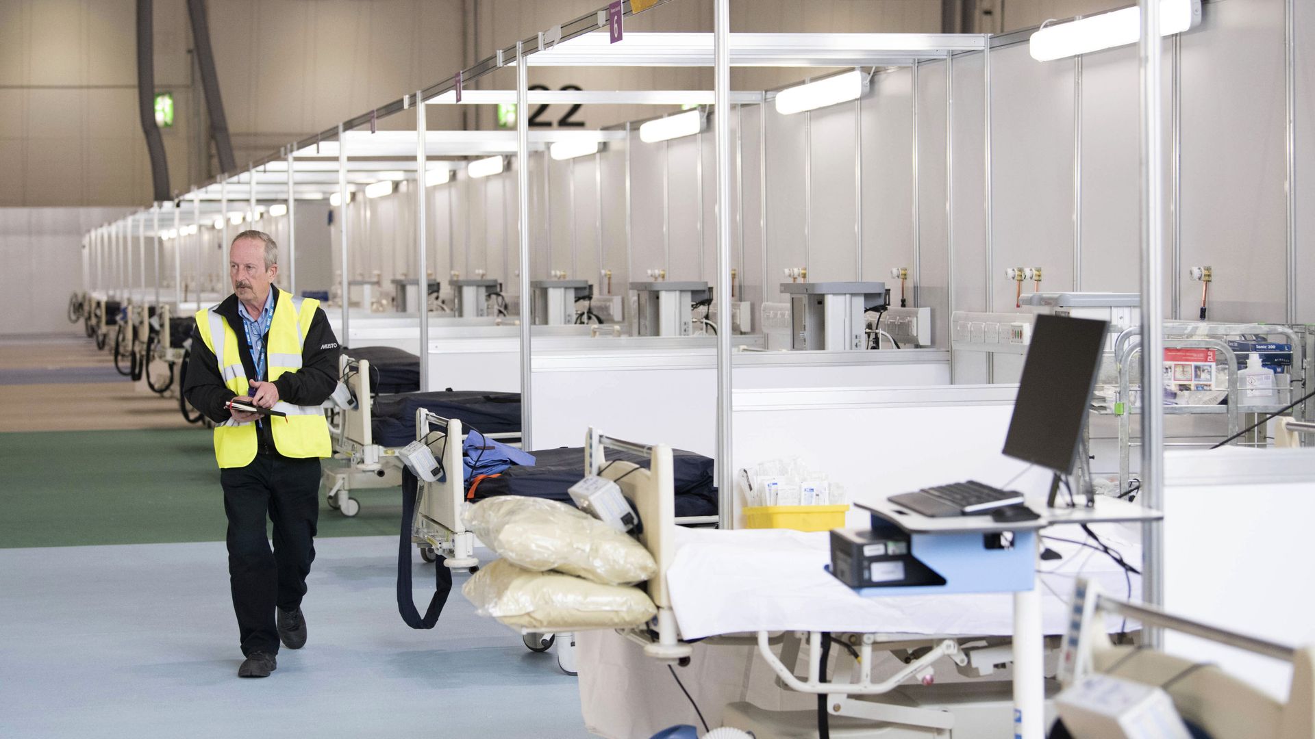 A private contractor walks down a ward at the ExCel centre which has temporarily been transformed into the NHS Nightingale hospital, in London, Monday, March 30, 2020. The makeshift hospital comprises of two wards with the capacity to hold up to 2,000 people in each - Sputnik International, 1920, 24.11.2021