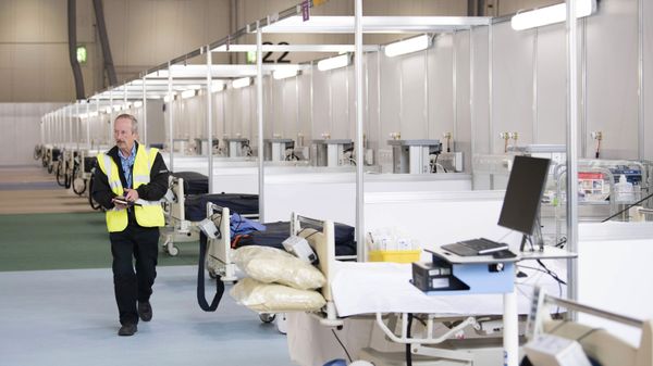 A private contractor walks down a ward at the ExCel centre which has temporarily been transformed into the NHS Nightingale hospital, in London, Monday, March 30, 2020. The makeshift hospital comprises of two wards with the capacity to hold up to 2,000 people in each - Sputnik International