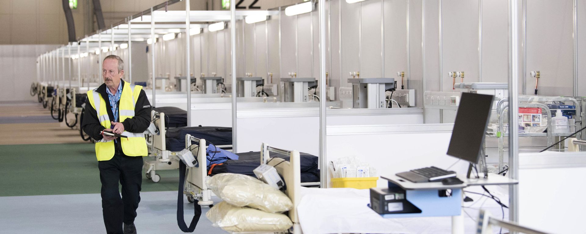 A private contractor walks down a ward at the ExCel centre which has temporarily been transformed into the NHS Nightingale hospital, in London, Monday, March 30, 2020. The makeshift hospital comprises of two wards with the capacity to hold up to 2,000 people in each - Sputnik International, 1920, 28.06.2022