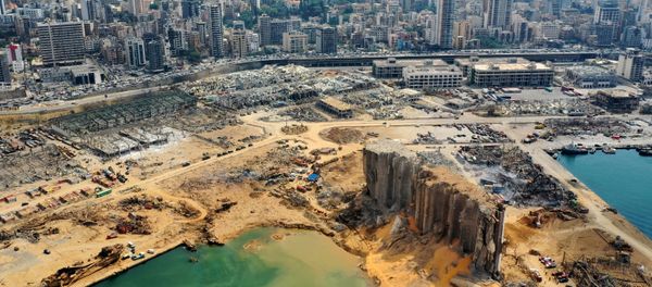 An aerial view taken on August 7, 2020, shows a partial view of the port of Beirut, the damaged grain silo and the crater caused by the colossal explosion three days earlier of a huge pile of ammonium nitrate that had languished for years in a port warehouse, leaving scores of people dead or injured and causing devastation in the Lebanese capital. The city of Beirut can be seen in the background. An aerial view taken on August 7, 2020, shows a partial view of the port of Beirut, the damaged grain silo and the crater caused by the colossal explosion three days earlier of a huge pile of ammonium nitrate that had languished for years in a port warehouse, leaving scores of people dead or injured and causing devastation in the Lebanese capital. The city of Beirut can be seen in the background. - Sputnik International