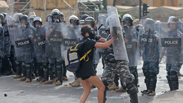A Lebanese policeman hits a demonstrator during clashes in downtown Beirut on August 8, 2020, following a demonstration against a political leadership they blame for a monster explosion that killed more than 150 people and disfigured the capital Beirut. - Sputnik International