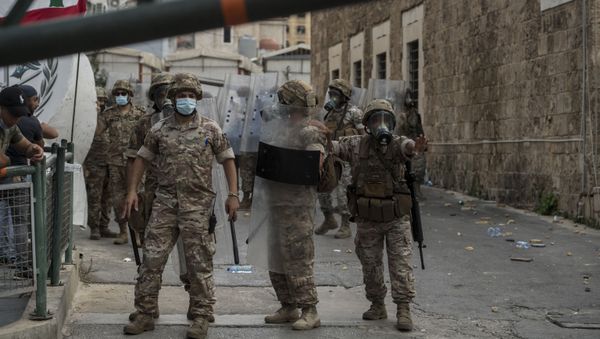 Riot police officers block a street during clashes with protesters demanding the resignation of the government and social reforms, in central Beirut, Lebanon. - Sputnik International