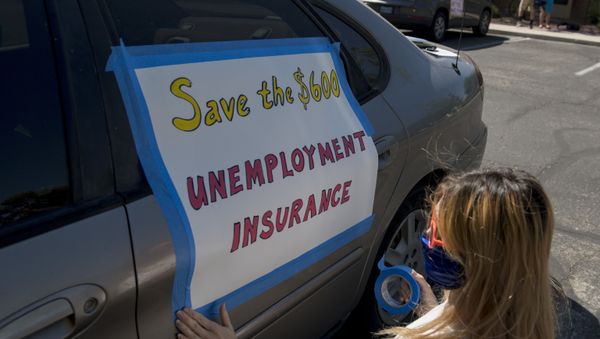 Francis Stallings tapes signs to her car before participating in a caravan rally down the Las Vegas Strip in support of extending the $600 unemployment benefit, August 6, 2020 in Las Vegas, Nevada. - Sputnik International