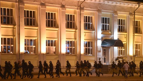 Riot police run as opposition supporters protest after polls closed in Belarus' presidential election, in Minsk on August 9, 2020. - Sputnik International
