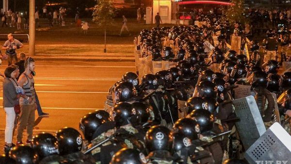 Opposition supporters stay in front of law enforcement officers blocking a street after poll closed at presidential election in Minsk, Belarus, August 9, 2020. Opposition supporters stay in front of law enforcement officers blocking a street after poll closed at presidential election in Minsk, Belarus, August 9, 2020. - Sputnik International