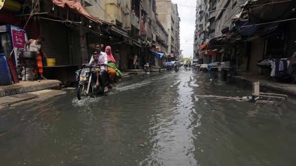 A motorcyclist drives through a street flooded by heavy rainfall in Karachi, Pakistan, Sunday, Aug. 9, 2020 - Sputnik International