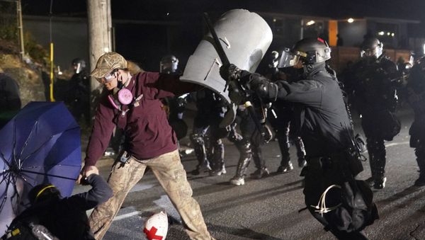 A Portland police officer shoves a protester as police try to disperse the crowd in front of the Multnomah County Sheriff's Office early in the morning on Saturday, Aug. 8, 2020 in Portland, Ore. - Sputnik International